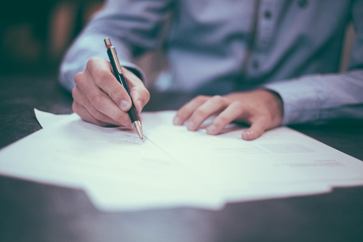 Person writing on a clipboard checklist